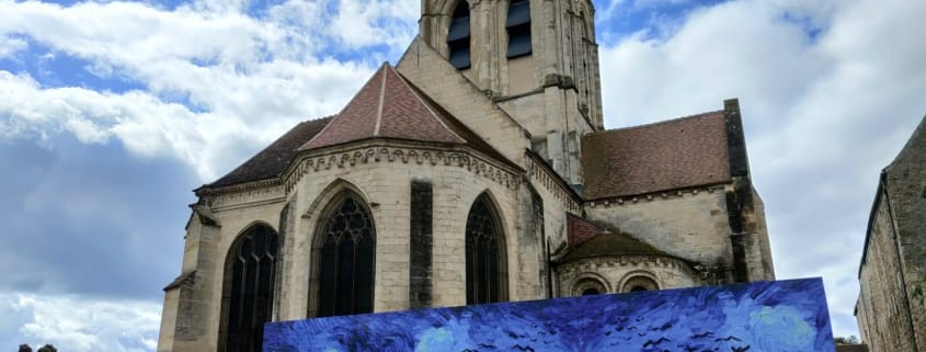 De kerk Notre-Dame-de-l'Assomption in Auvers-sur-Oise met een reproductie van Van Goghs Korenveld met kraaien